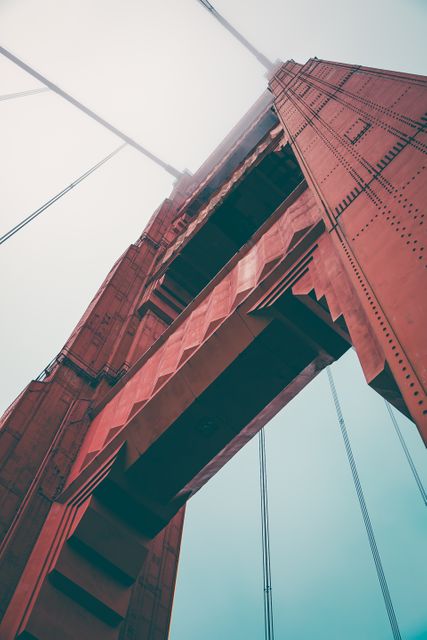 Close-up view of the Golden Gate Bridge tower enveloped in fog. Ideal for travel brochures, architectural presentations, and projects emphasizing iconic structures or engineering marvels. With its distinctive red color and foggy ambiance, it captures the essence of San Francisco's famous landmark.