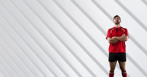 Confident rugby player in red uniform arms crossed