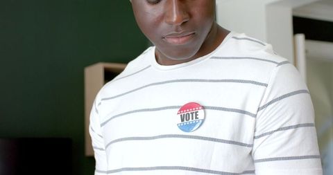 Young man wearing vote badge promotes civic engagement