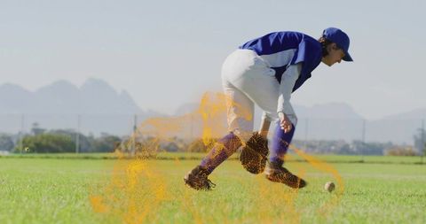 Youth baseball player fielding ball on sunny pitching mound