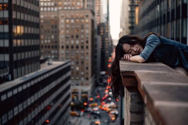 Young woman resting on city balcony at sunset - Download Free Stock Images Pikwizard.com