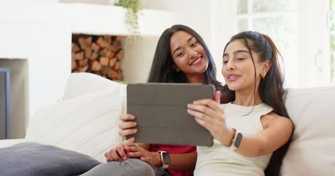 Diverse Female Friends Enjoying Tablet in Cozy Living Room