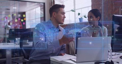 Collaborating colleagues discussing data visualization over laptop in modern open office