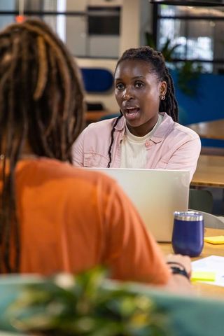 African American Coworkers Discussing Project at Bright Modern Open-Plan Workspace