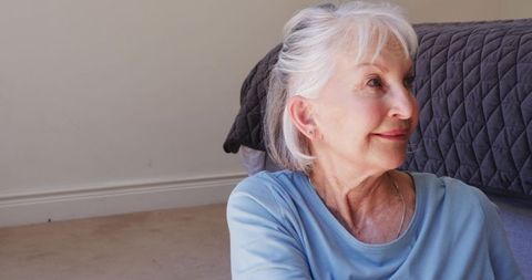 Elderly woman relaxing indoors with tranquil expression