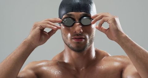 Focused Swimmer Adjusting Goggles Before Competitive Swim