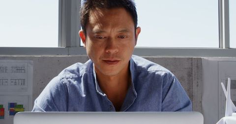 Focused Architect in Modern Office Using Laptop