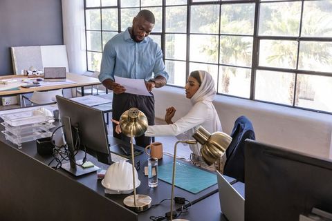 Diverse Coworkers Collaborating in Modern Workplace with Technology