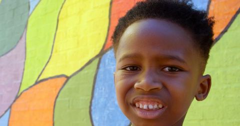 Smiling Schoolboy in Front of Colorful Mural