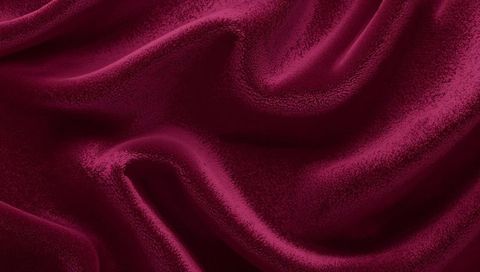Draping deep wine-red velvet fabric revealing plush folds and soft sheen