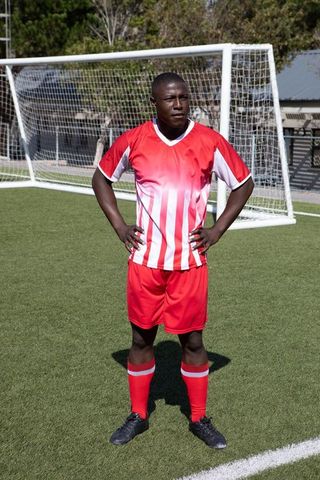 Soccer Player Standing Proudly on Field by Goal Post