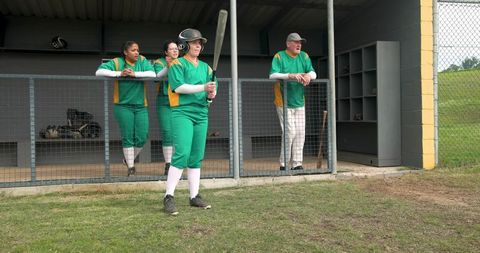 Diverse Softball Team Preparing for Game in Dugout