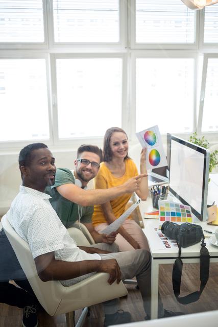 Group of graphic designers working on computer in office