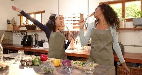 Joyful Mother and Daughter in Rustic Kitchen Cooking Together
