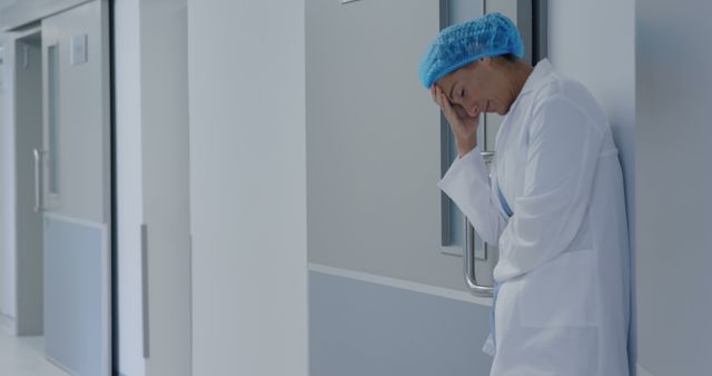 Exhausted Medical Professional Leaning Against Hospital Wall - Download Free Stock Images Pikwizard.com