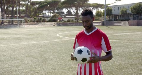 African American Athlete Holding Soccer Ball on Field