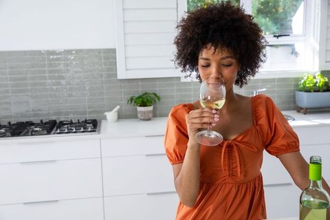 Young Woman Enjoying Glass of Wine in Modern Kitchen