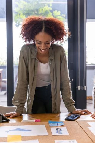 Creative Woman Reviewing Design Sketches in Modern Studio