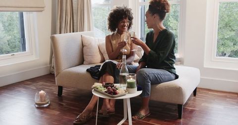 Same-Sex Female Couple Relaxing with Champagne at Home
