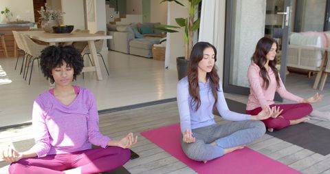 Diverse Women Meditating on Outdoor Wooden Deck