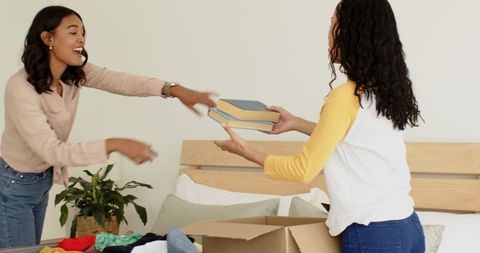 Woman unpacking clothes at home in casual bedroom setting