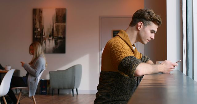 Young man using smartphone in modern cafe - Download Free Stock Images Pikwizard.com