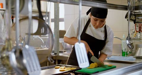 female chef dicing vegetables in restaurant kitchen - Download Free Stock Images Pikwizard.com