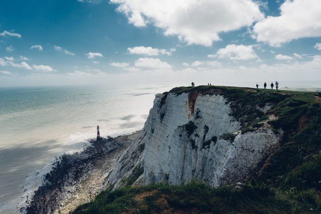 Group of People Standing on Idyllic Cliff Overlooking Scenic Ocean - Download Free Stock Photos Pikwizard.com