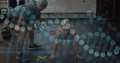Woman holding plank while coach spotting with digital fitness data overlay