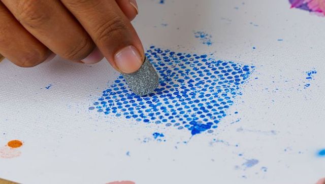 Hand stamping blue dot grid with sponge for abstract texture close-up