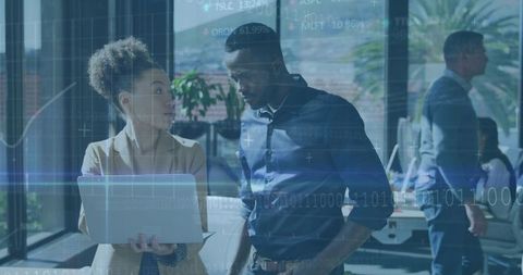 Collaborating over laptop with digital analytics overlay in modern open office environment