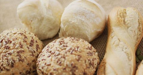 Assorted artisan bread rolls on burlap cloth