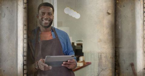 Smiling Barista Using Tablet at Coffee Shop Entrance