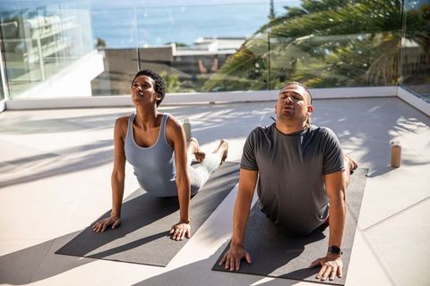 Couple Practicing Yoga on Terrace With Ocean View