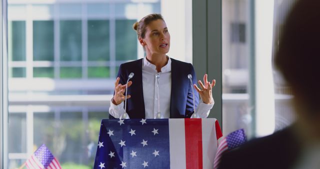 Confident Female Politician Giving Speech at Podium with American Flag - Download Free Stock Images Pikwizard.com