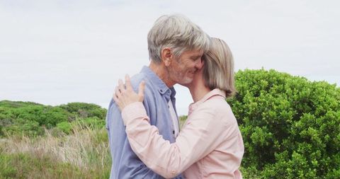 Senior Couple Embracing Outdoors with Lush Greenery - Download Free Stock Images Pikwizard.com