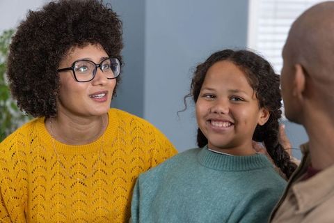 African american family chatting and smiling in cozy living room, parent and child bonding