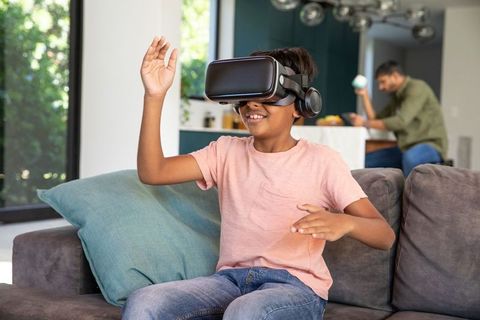 Child enjoying vr adventure at home with parent nearby