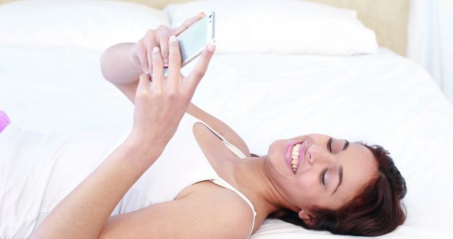 Happy Young Woman Texting on Smartphone in Bed - Download Free Stock Images Pikwizard.com