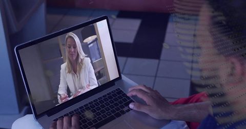 Remote business meeting featuring professional woman on laptop screen, hands typing