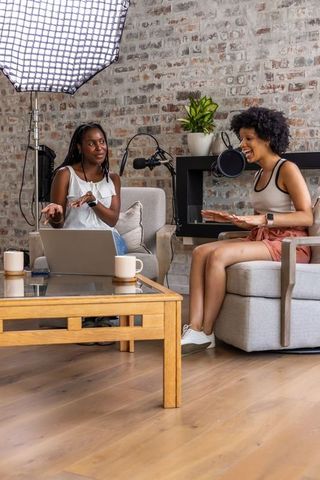 African american women recording lively podcast in cozy home studio with microphones