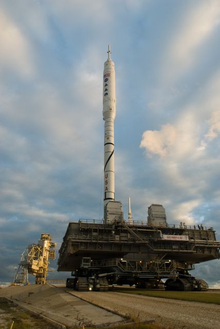 Ares I-X rocket making its journey to Launch Pad 39B at Kennedy Space Center, demonstrating NASA’s commitment to advancing space exploration projects. This image can be used in articles related to space history, NASA missions, rocketry engineering, and technological advancements in space travel.