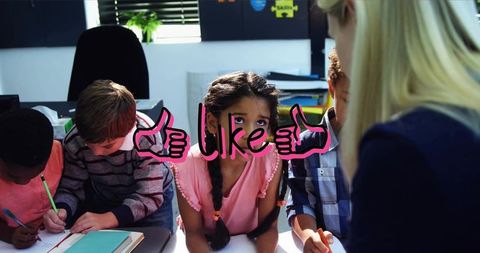 Teacher guiding elementary students during collaborative learning session with pink like graphic