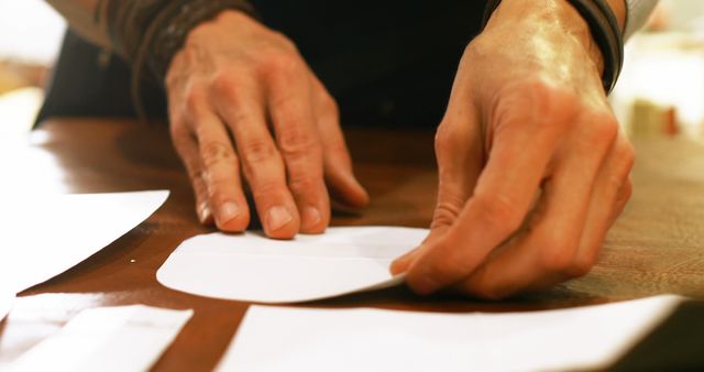 Close-Up of Male Hands Crafting with Paper on Wooden Table - Download Free Stock Images Pikwizard.com