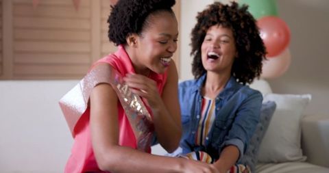 Joyful Diverse Couple Celebrating Birthday With Lit Cake at Home