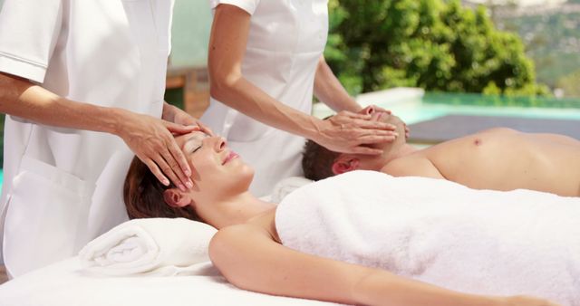 Couple is receiving soothing outdoor massages at a luxury tropical resort. Perfect for promoting relaxation and spa services, wellness retreats, and travel packages. Image captures peaceful atmosphere and professional care of spa therapists, ideal for illustrating spa experiences and luxury holiday destinations.