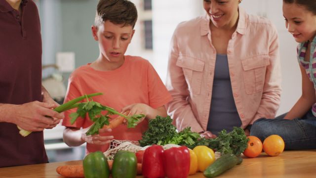 A family is gathered in a brightly lit kitchen, unpacking fresh vegetables for meal preparation. The scene conveys happiness and togetherness as they enjoy bonding over healthy food choices. This image can be used for themes related to family life, healthy eating, meal preparation, home activities, or promoting nutritious diets.