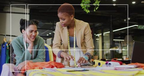 Designers Collaborating on Fabric Patterns in Fashion Studio