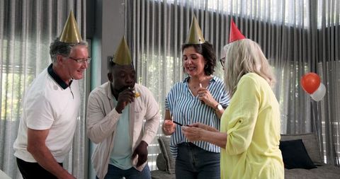 Joyful coworkers celebrating with sparklers at office party