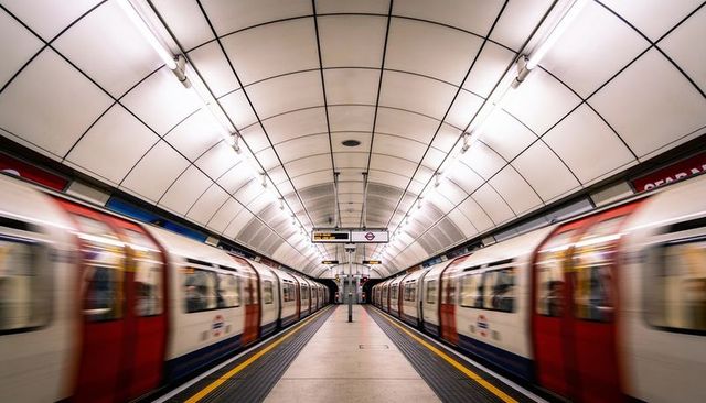 Symmetrical london underground central platform with passing trains, motion blur, modern architectur